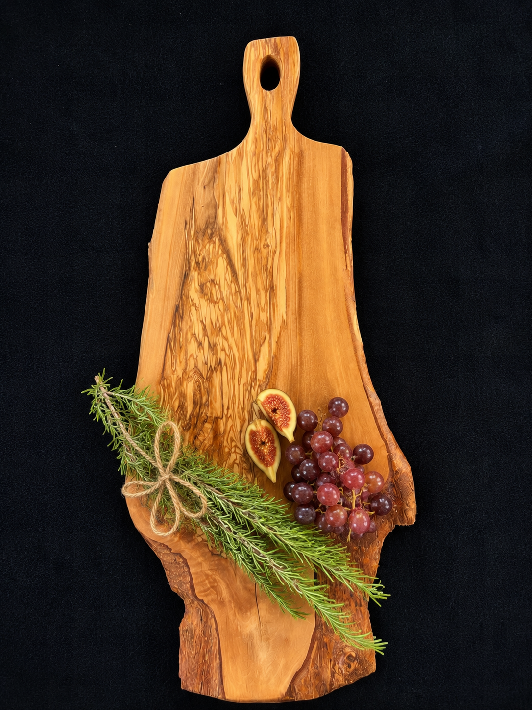 Live edge olive wood serving board styled with grapes, figs, rosemary, and charcuterie for entertaining.