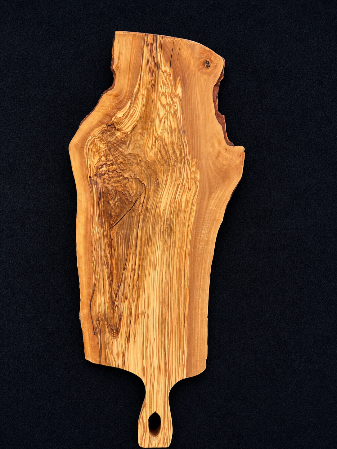One-of-a-kind olive wood gathering board with natural live edge and dramatic grain.