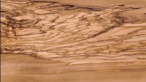 Close-up of the dramatic figured grain in a handcrafted olive wood serving board.