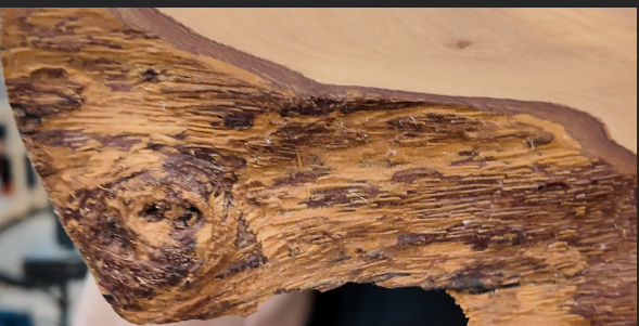 Natural live edge and knot detail on a one-of-a-kind olive wood board.